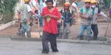 Mendigo camina sobre una calle recién pavimentada frente a los obreros [VIDEO]