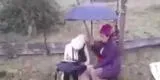 Niña estudia bajo la lluvia mientras su mamá la cubre con un paraguas: "Solo aquí tengo conexión"