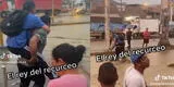 Peruano se gana la vida cargando a los transeúntes a cruzar la pista inundada por los huaicos