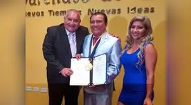Cómico muestra orgulloso su premio junto a sus amigos y familiares.