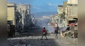 Residentes de un suburbio de Haití caminan por sus calles poco después de un tiroteo entre bandas criminales el 20 de diciembre de 2019.