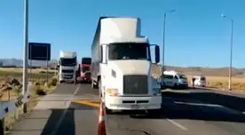Se observa a varios camiones y vehículos particulares sin poder avanzar debido a las piedras colocadas en la vía.