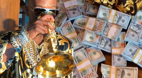 Floyd Mayweather presume su fortuna al beber en copa de oro y con millones de dólares