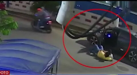 Hombre tirado en el suelo junto a su hijo tras ser asaltado.