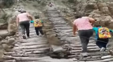Una mujer y sus hijos arriesgan sus vidas al cruzar un puente en mal estado.