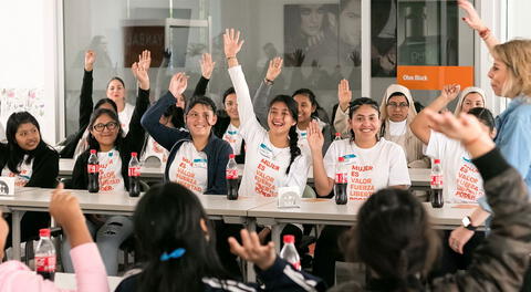 Mujeres siendo capacitadas sobre el empoderamiento por empresa de cosméticos.