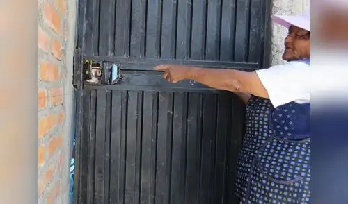 La señora muestra como fracturaron su puerta. elpopular.pe