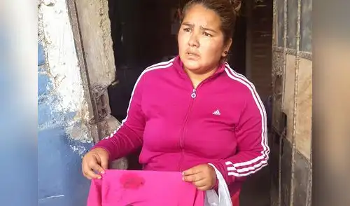 La mamá mostrando la ropa de su hijita herida. elpopular.pe