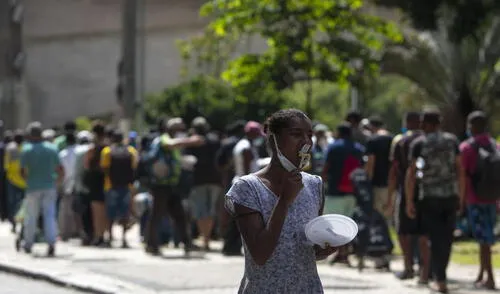 Personas sin hogar reciben almuerzo en el centro de Sao Paulo, Brasil, el 23 de marzo de 2021, en medio de la pandemia de coronavirus. elpopular.pe