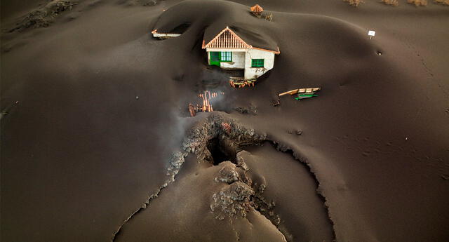 El gran impacto del volcán. En la foto se aprecia la boca por la que salió la lava al pie de una casa que milagrosamente ha sobrevivido.