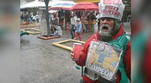 Entre la muchedumbre, un anciano se viste de Papá Noel para no pasar inadvertido. Solo pide un pan.