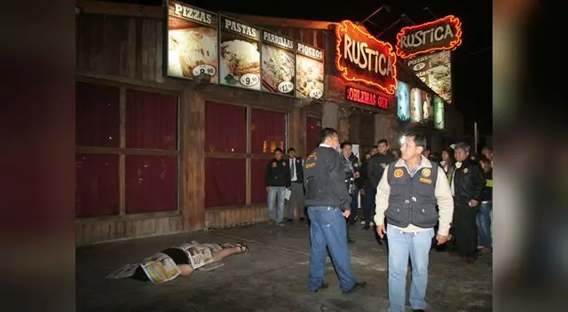 el cuerpo de la mujer yace en el pavimento en las afueras del local.