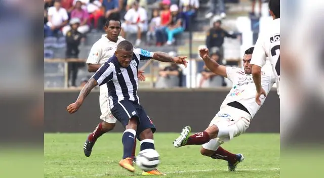 Aguirre ensaya un remate que un defensa visitante interceptará.