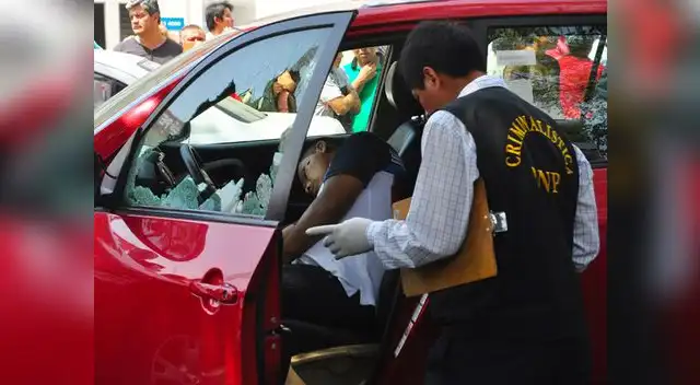 Peritos en criminalística revisan la camioneta donde fue ultimado reyes.