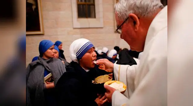El mundo vive la Navidad desde distintos puntos de vista (monja recibe la comunión durante misa en Belén).