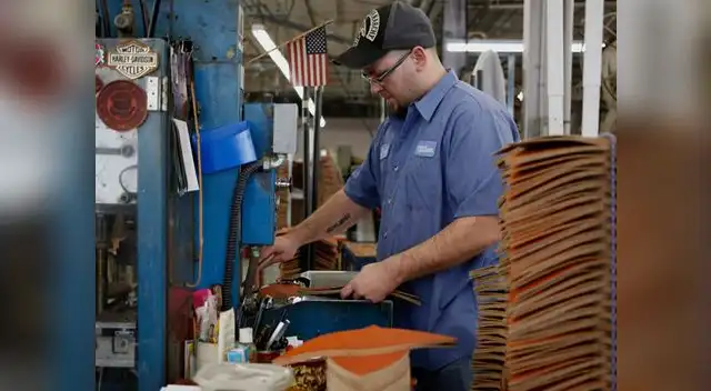 Un trabajador se encarga de unir las piezas de cuero