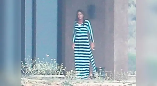 Bruce Jenner con cigarro en manos, vestido y tacones.