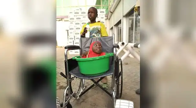 Rahama Haruna y su hermano, con la silla de ruedas que recibieron de regalo.