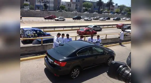 Peritos de criminilística examinan el vehículo acribillado.