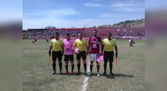 capitanes de ambos equipos posan con la terna al inicio del cotejo