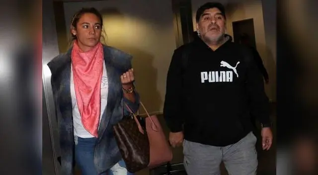 Maradona retirándose del aeropuerto con su novia.