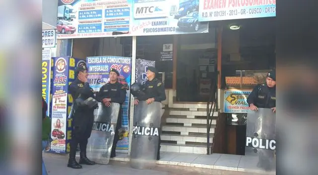 La policía custodiando una local de escuela de conductores La policía custodiando una local de escuela de conductores