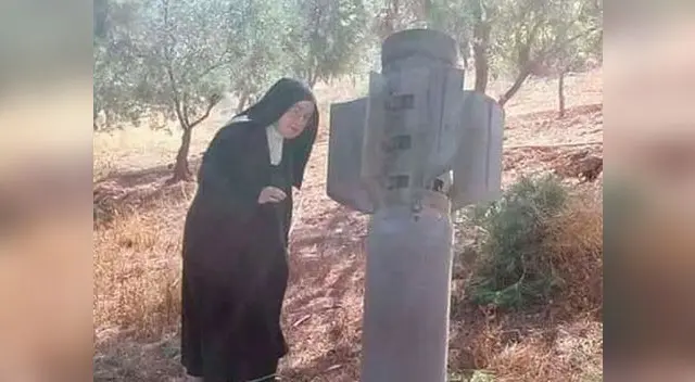 Monja mira con detenimiento el misil que no estalló en el convento de Alepo, en Siria