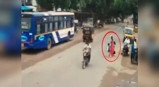 Madre llevaba de la mano a sus dos hijos mientras esperaban cruzar la pista 