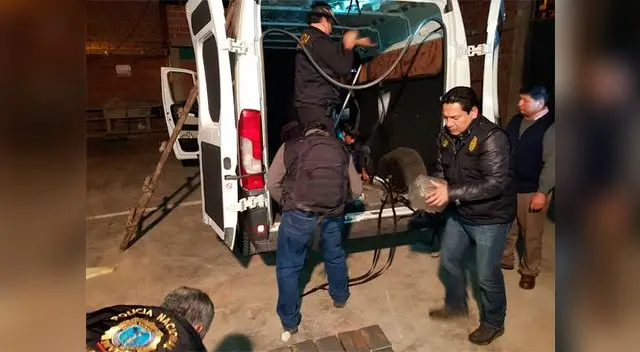 Los policías realizando el conteo de los paquetes con droga Los policías realizando el conteo de los paquetes con droga