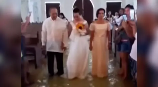 pareja de filipinos se casan a pesar de inundación en la iglesia. Foto captura de video en YouTube pareja de filipinos se casan a pesar de inundación en la iglesia. Foto captura de video en YouTube