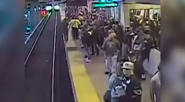 Instante en que el hombre está a punto de caer en los rieles