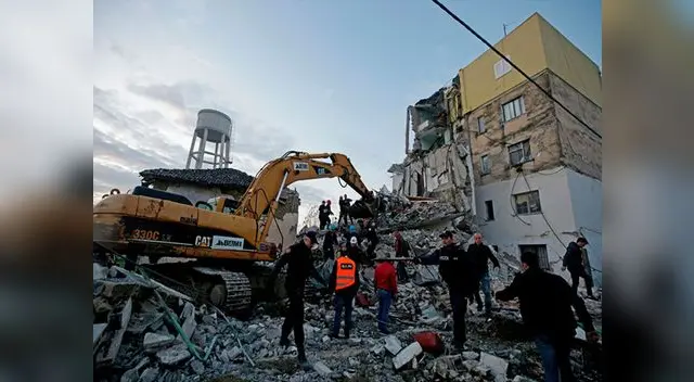 Personas de emergencias trabajan entre las ruinas de un edificio de viviendas en Thumane