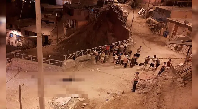 El cadáver ante la mirada de la policía y vecinos.