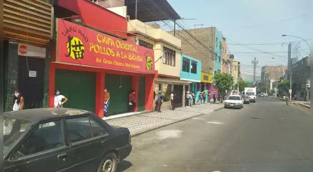 Personal del Banco de la Nación brinda alcohol en gel a las personas en las colas.