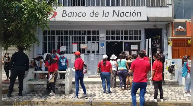 Personal del Banco de la Nación brinda alcohol en gel a las personas en las colas.