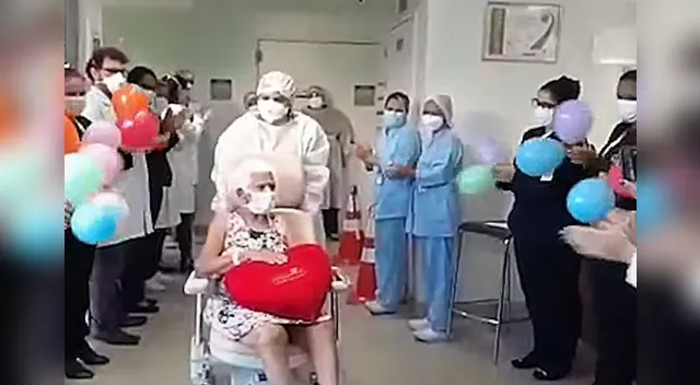 La longeva mujer salió del hospital en silla de ruedas entre globos y aplausos del personal médico. La longeva mujer salió del hospital en silla de ruedas entre globos y aplausos del personal médico.