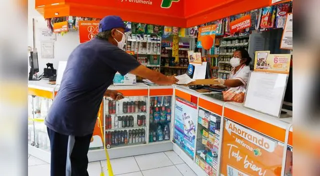 Las cajeras de las farmacias usan un vidrio para atender al cliente y colocan un pedazo de cartón para recibir el dinero por el medicamento.