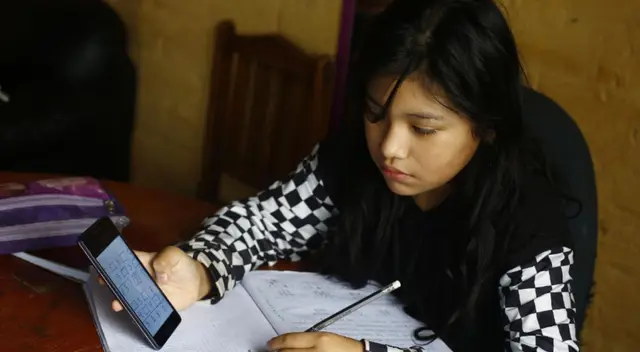 Padres de familia acompañan a sus hijos en clases virtuales o tele educación dentro de su casa. Padres de familia acompañan a sus hijos en clases virtuales o tele educación dentro de su casa.