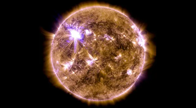 Una llamarada solar de clase X destella en el borde del Sol y muestra un tipo de luz que es invisible para los ojos humanos, llamada luz ultravioleta extrema.