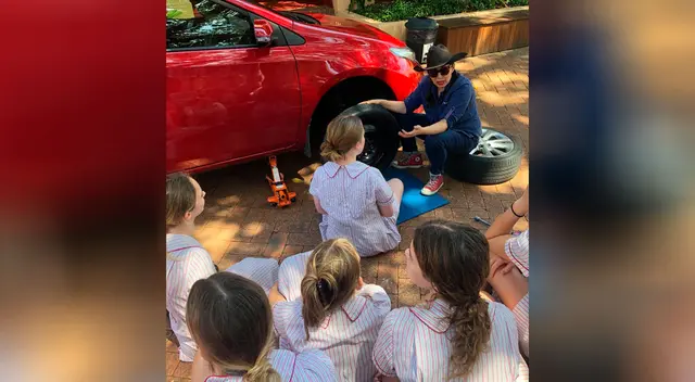 Escuela enseña a adolescentes cómo cambiar las llantas de un auto