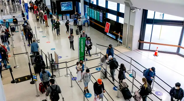 Los viajeros con máscaras esperan para pasar por seguridad en el Aeropuerto Internacional de San Francisco el 24 de noviembre. Los viajeros con máscaras esperan para pasar por seguridad en el Aeropuerto Internacional de San Francisco el 24 de noviembre.