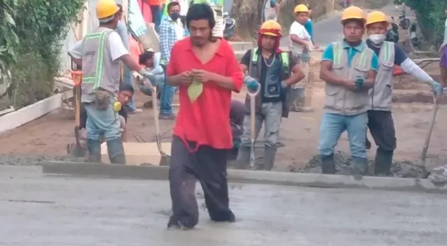 Despistado hombre camina sobre una calle recién pavimentada