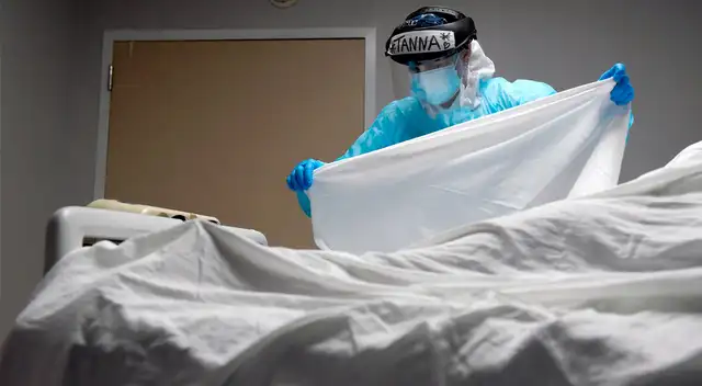 Enfermera coloca una sábana sobre el cuerpo de un paciente que murió COVID-19 en el United Memorial Medical Center en Houston el 30 de diciembre de 2020. Enfermera coloca una sábana sobre el cuerpo de un paciente que murió COVID-19 en el United Memorial Medical Center en Houston el 30 de diciembre de 2020.