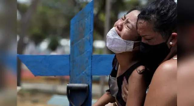 Imagen de archivo de dos personas llorando por la muerte de un familiar en el cementerio Parque Taruma de Manaos, Brasil. 17 enero 2021.