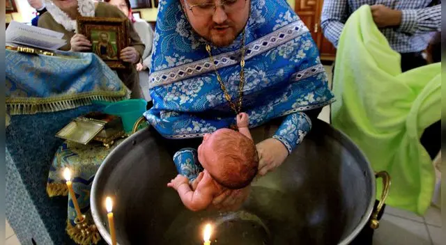 El bautismo tradicional de la Iglesia Ortodoxa Rumana consiste en sumergir tres veces la cabeza del recién nacido en el agua.
