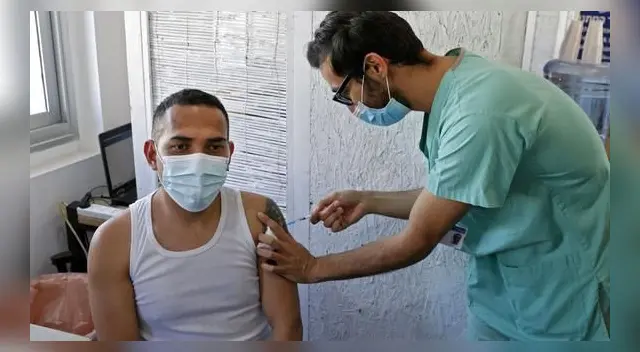 Un extranjero que vive en Israel recibe una dosis de la vacuna contra el coronavirus COVID-19 en el Centro Médico Tel Aviv Sourasky. (Foto de JACK GUEZ / AFP).