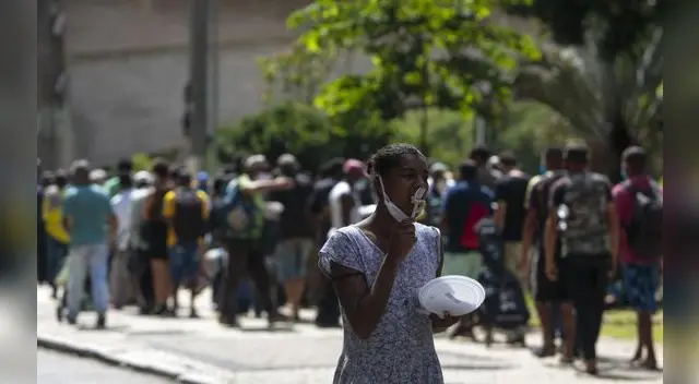 Personas sin hogar reciben almuerzo en el centro de Sao Paulo, Brasil, el 23 de marzo de 2021, en medio de la pandemia de coronavirus.