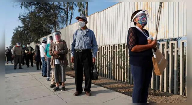 Votantes hacen fila para ingresar a un centro electoral hoy, en el distrito de Villa El Salvador, en Lima.