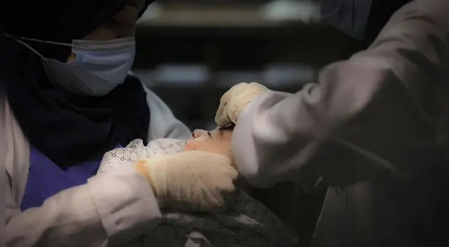 Un bebé rescatado de los escombros tras el ataque israelí a un campamento de refugiados en Gaza, el 15 de mayo de 2021.