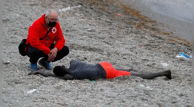 Personal de Cruz Roja con un migrante llegado a la playa de Tarajal, Ceuta, 18 de mayo de 2021.